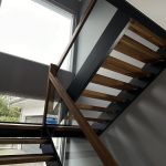 Weiß gestrichenes Treppenhaus mit brauner Wendeltreppe