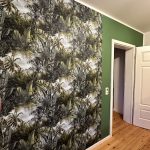 Grün gestrichener Raum mit Akzenttapete mit grünem Pflanzenmotiv